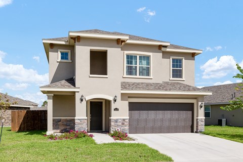 A two-story house with a garage door and a driveway.